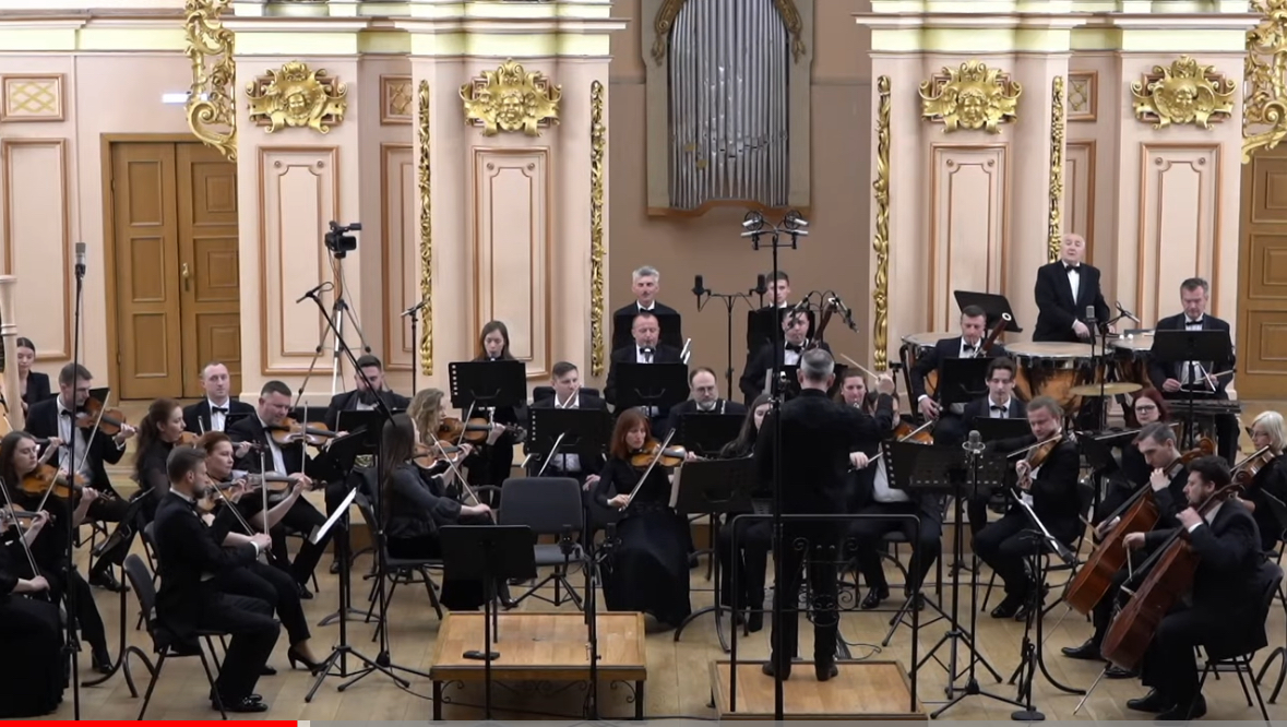 Orchestra performing in an ornate concert hall